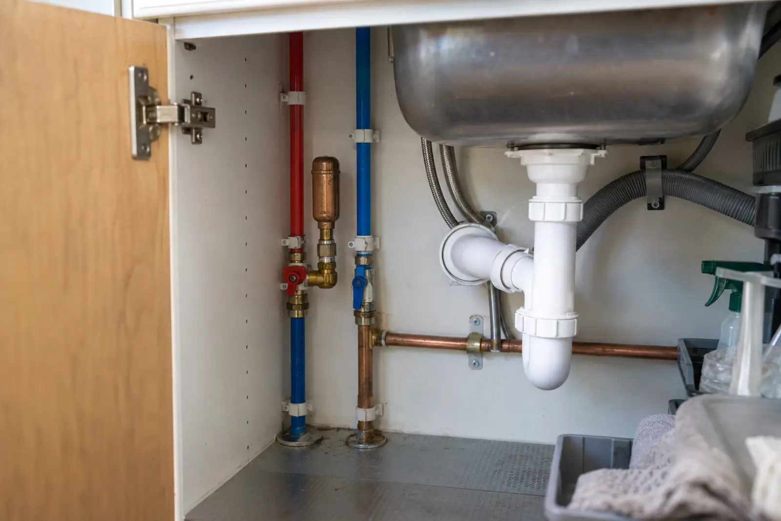 Instalacja wodna pod zlewem z rurami, zaworami i tłumikiem uderzeń hydraulicznych